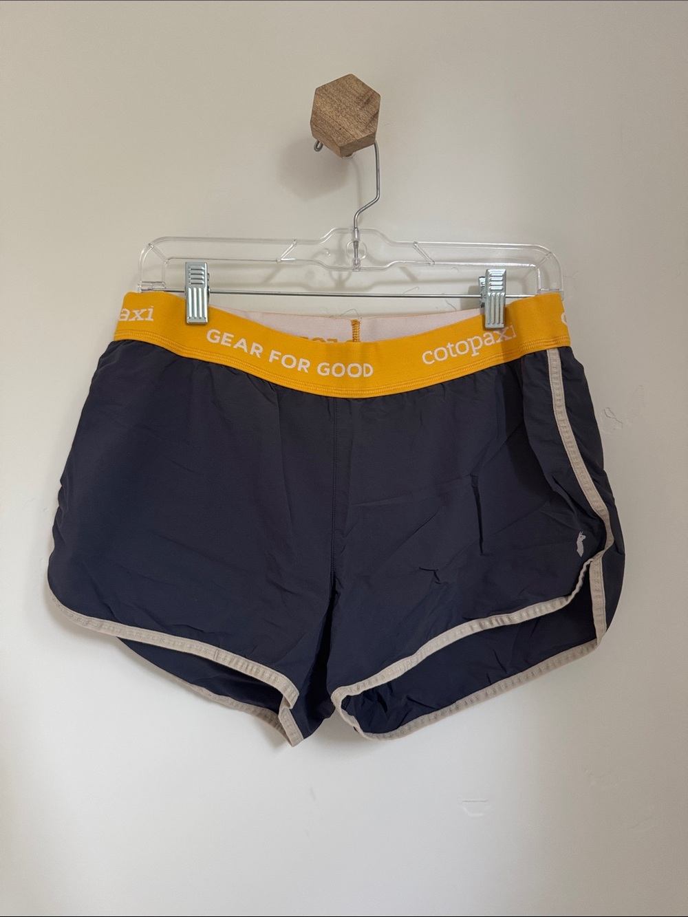 cotopaxi navy athletic shorts with yellow waistband